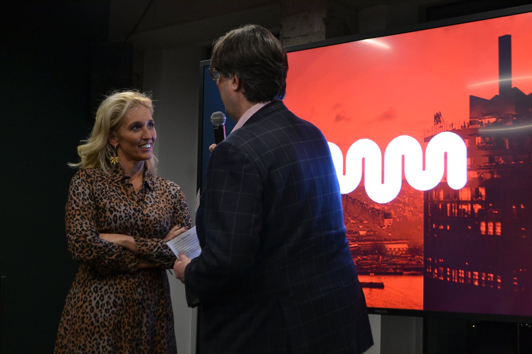 Een vrouw en een man in gesprek met een microfoon